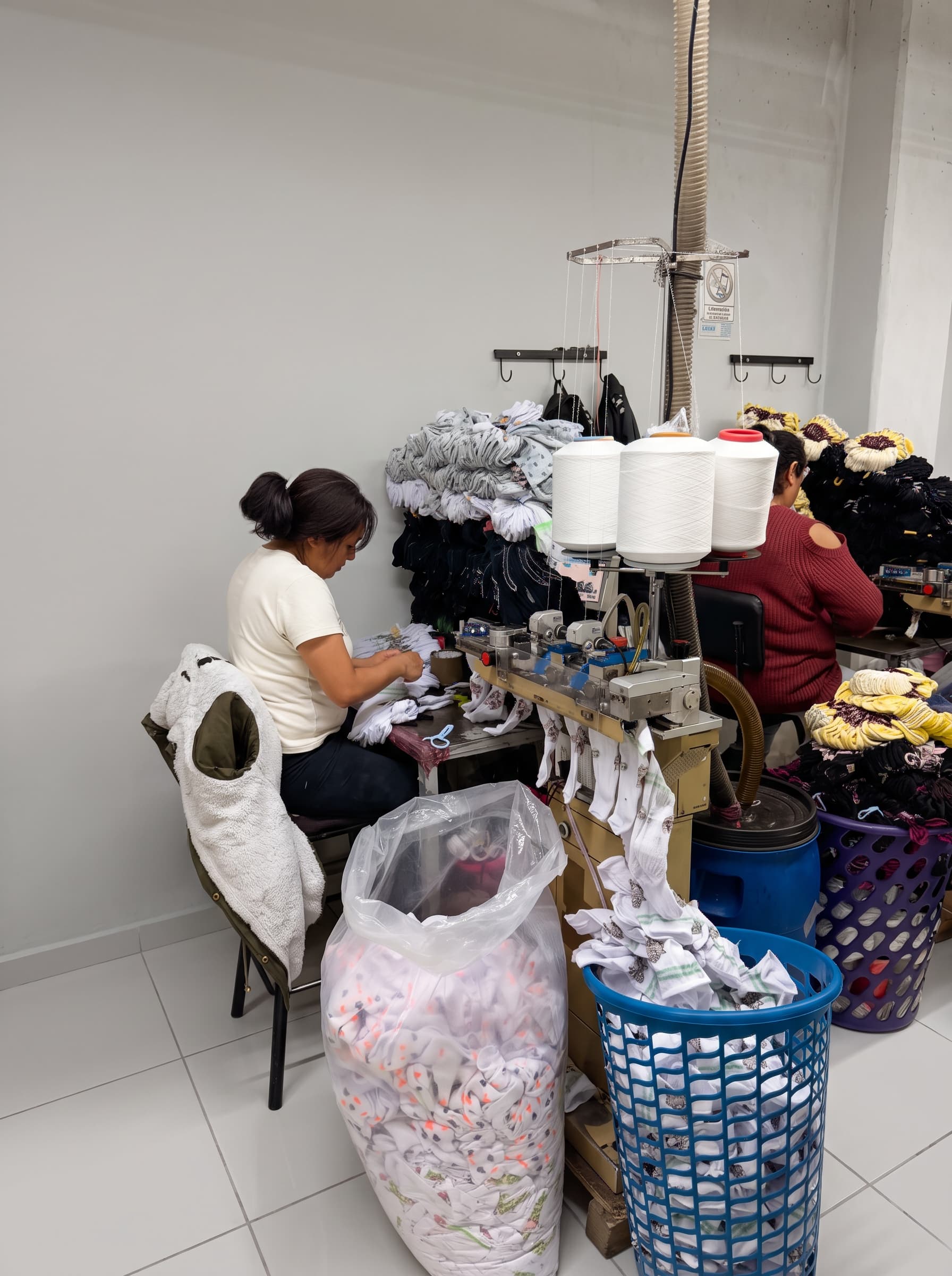 Operarias rematando la punta de las calcetas en máquina remalladora